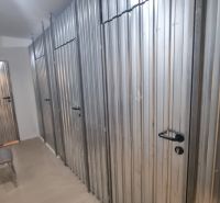 2-izbový moderný byt, s garážovým státím  novostavba, Coboriho ulica - Skladové priestory s kovovými dverami a stoličkou v 2-izbovom byte.