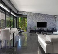 ARCHITEKTÚRA TICHA A MODERNÝCH TECHNOLÓGIÍ - SMART VILLA V OBJATÍ LESA - Obývacia izba s bielym nábytkom a televízorom v rodinnom dome, podlaha s dreveným dekorom.