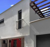 ARCHITEKTÚRA TICHA A MODERNÝCH TECHNOLÓGIÍ - SMART VILLA V OBJATÍ LESA - Rodinný dom na Záhradnej ulici v Lukavici so svetlou fasádou a drevenou pergolou.