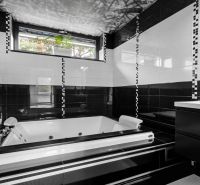 ARCHITEKTÚRA TICHA A MODERNÝCH TECHNOLÓGIÍ - SMART VILLA V OBJATÍ LESA - Čiernobiela kúpeľňa s vaňou a oknom v Rodinnom dome.