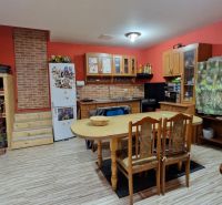 Rodinný dom s veľkorysou prístavbou v obci Parchovany - Kuchyňa v rodinnom dome s podlahou s dreveným dekorom a dreveným nábytkom.