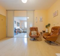 Na predaj 4 izbový byt - SKVELÁ LOKALITA - Bratislava - Interiér 4-izbového bytu s koženými kreslami a podlahou s dreveným dekorom.