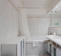 Na predaj 4 izbový byt - SKVELÁ LOKALITA - Bratislava - Kúpeľňa so sprchou a vaňou v 4-izbovom byte s bielym obkladom.