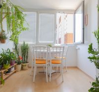Na predaj 4 izbový byt - SKVELÁ LOKALITA - Bratislava - Interiér 4-izbového bytu s rastlinami, bielym stolom a podlahou s dreveným dekorom.