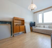 Na predaj 4 izbový byt - SKVELÁ LOKALITA - Bratislava - Obývacia izba v 4-izbovom byte s podlahou s dreveným dekorom a nábytkom.