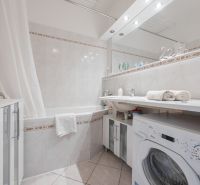 Na predaj 4 izbový byt - SKVELÁ LOKALITA - Bratislava - Kúpeľňa so sprchovacím závesom, umývadlom a pračkou v 4-izbovom byte.