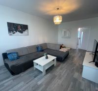 VESTAREAL | Na predaj priestranný 3-izbový byt s balkónom Galanta - Obývacia izba s pohovkou, konferenčným stolíkom a podlahou s dreveným dekorom v 3-izbovom byte.