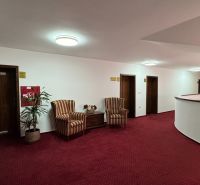 NA PREDAJ hotel s reštauráciou - Chodba s červeným kobercom, kreslami a izbami vo vnútri hotela alebo penziónu.