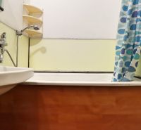 Pôvodný stav, neobmedzené možnosti | 3-izbový byt v centre Púchova  - Kúpeľňa s vaňou a umývadlom v 3-izbovom byte, s podlahou s dreveným dekorom.