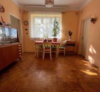 Rodinný dom v Záhorskej Bystrici na ulici Donská - Izba v rodinnom dome s podlahou s dreveným dekorom, jedálenským stolom a vitrínou.