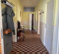 Rodinný dom v Záhorskej Bystrici na ulici Donská - Kachličková podlaha, žlté steny a kabát na vešiaku v chodbe rodinného domu.