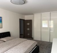 Ponúkame na predaj veľký 2 i byt v Nových Zámkoch, ul. Šafárikova ! - Spálňa v 2-izbovom byte s veľkou vstavanou skriňou a čalúneným čelom postele.