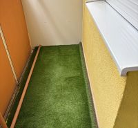Ponúkame na predaj veľký 2 i byt v Nových Zámkoch, ul. Šafárikova ! - Balkón 2-izbového bytu na Šafárikovej ulici v Nových Zámkoch, podlaha s umelou trávou.