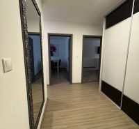 Ponúkame na predaj veľký 2 i byt v Nových Zámkoch, ul. Šafárikova ! - Chodba v 2-izbovom byte s podlahou s dreveným dekorom a zrkadlom na stene.