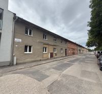 2-izbový byt s vlastnou záhradkou,plynovým kotlom, špajzou  - Ulica Námestie Jozefa Emanuela vo Vrbovom, radové domy a autá na ceste.