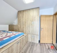 Útulný 3 izbový byt na Donovaloch - Spálňa v 3-izbovom byte s podlahou s dreveným dekorom a vstavanými skriňami.