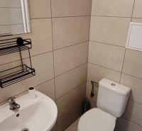 Väčší 1 izbový byt na prenájom v Komárne - Kúpeľňa v 1-izbovom byte s WC, umývadlom a svetlou dlažbou.