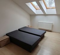 Na prenájom 3  izbový byt v Komárne - Spálňa v 3-izbovom byte s posteľami, strešnými oknami a podlahou s dreveným dekorom.