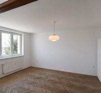 Priestranný 3-izbový byt | 72 m² + 9 m² loggia + 9 m² pivnica |  - Obývacia izba v 3-izbovom byte s podlahou s dreveným dekorom a veľkými oknami.