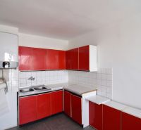 Priestranný 3-izbový byt | 72 m² + 9 m² loggia + 9 m² pivnica |  - Červená kuchyňa v 3-izbovom byte s bielymi obkladačkami a umývadlom.