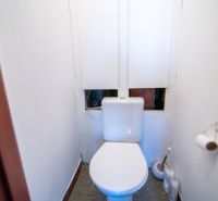 Priestranný 3-izbový byt | 72 m² + 9 m² loggia + 9 m² pivnica |  - Toaleta s bielymi stenami a podlahou s dreveným dekorom v 3-izbovom byte.