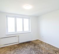 Priestranný 3-izbový byt | 72 m² + 9 m² loggia + 9 m² pivnica |  - Priestor s bielymi stenami, veľkým oknom a podlahou s dreveným dekorom v 3-izbovom byte.