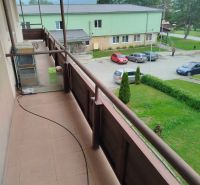 Garsónka - Balkón garsónky na Na Rovni v Ľubotíne s výhľadom na parkovisko a zeleň.