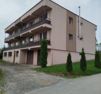 Garsónka - Trojposchodový bytový dom v Ľubotíne na ulici Na Rovni s balkónmi a zeleňou.