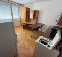 Garsonka Topoľčany / PRENAJOM - Garsónka s podlahou s dreveným dekorom, kuchynským kútom, stolom a práčkou.