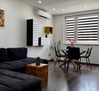 3-izbový byt | 79 m² | Komárno – sídlisko gen. Klapku - Obývacia izba s podlahou s dreveným dekorom a nábytkom v 3-izbovom byte.