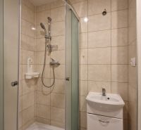 AstonReal: na predaj 2-izbový byt 54 m2 - Poprad, Komenského - Kúpeľňa so sprchovacím kútom a umývadlom v 2-izbovom byte, obkladané steny.