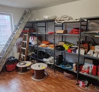 Komerčný objekt na predaj  v Komárne - Interiér budovy s regálmi a uloženým materiálom na podlahe s dreveným dekorom.
