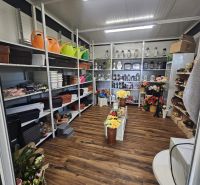 NA PREDAJ *** PREVÁDZKA  70M2 PRI HLAVNEJ CESTE V BERNOLÁKOVE *** - Interiér obchodných priestorov s regálmi plnými kvetináčov, svietnikov a umelých kvetov.