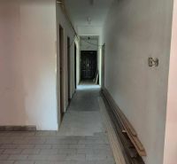 Komerčný objekt na predaj v Chotíne - Chodba v budove Komárna s dlažbou a hromadou stavebného materiálu.