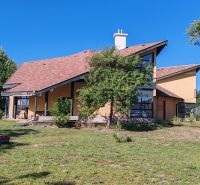 Komerčný objekt na predaj v Chotíne - Budova v Komárne s modernou architektúrou, obklopená zeleňou a modrou oblohou.