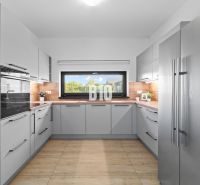 1 255 m² a 9 izieb I Priamo pri prírodnej rezervácii Šúr, len 15 minút - Kuchyňa s podlahou s dreveným dekorom, modernými spotrebičmi a veľkým oknom v rodinnom dome.