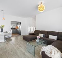 1 255 m² a 9 izieb I Priamo pri prírodnej rezervácii Šúr, len 15 minút - Obývacia izba v Rodinnom dome s pohovkou a jedálenským stolom, podlaha s dreveným dekorom.