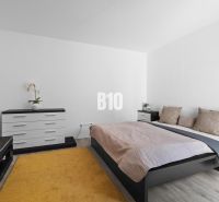 1 255 m² a 9 izieb I Priamo pri prírodnej rezervácii Šúr, len 15 minút - Spálňa s posteľou, komodou a podlahou s dreveným dekorom v rodinnom dome.