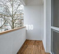 Dizajnový 2-izbový byt s loggiou a parkovaním na prenájom – Miletičova - Balkón 2-izbového bytu v Bratislave II s dreveným dekorom na podlahe.