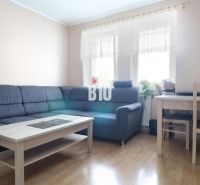 3 izbový byt Vrútky výhodná cena - Obývacia izba v 3-izbovom byte s rohovou sedačkou a dreveným dekorom podlahy.