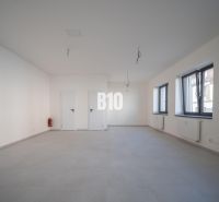 ADMINISTRATÍVNY PRIESTOR (127,87 m²) V NOVOSTAVBE REZIDENCIA KUBÍN V C - Prázdna kancelária s bielymi stenami, šedou podlahou a oknami bez závesov.