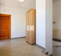 Obchodné priestory s charakterom v srdci Topoľčian – investícia, ktorá - Interiér obchodných priestorov s dlažbou, drevenými dverami a vstavanou skriňou.