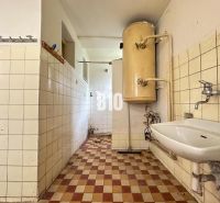 Rodinný dom s potenciálom v pokojnej lokalite – Nové Nosice, Púchov - Priestor s umývadlom a bojlerom v rodinnom dome, obložený dlaždičkami.