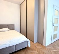 BÝVAJ PRVÝ v 1i BYTE, NOVÁ REKONŠTRUKCIA, BALKÓN, KLÍMA, Račianska ul. - Svetlá spálňa v 1-izbovom byte s podlahou s dreveným dekorom, posteľou a vstavanou skriňou.