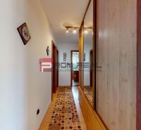 3D obhliadka - 4 izbový rodinný dom s bazénom v obci Tureň - Chodba v rodinnom dome s podlahou s dreveným dekorom a zrkadlovou skriňou.