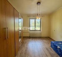 Na predaj 2 izbový byt na Sokolovskej ulici v meste Humenné - Izba v 2-izbovom byte s podlahou s dreveným dekorom a vstavanou skriňou.
