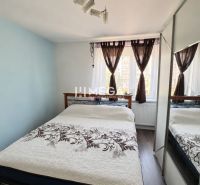 REZERVOVANÉ - Na predaj  4-izbový byt s veľkou lodžiou - Mierová ulica - Spálňa v 4-izbovom byte s podlahou s dreveným dekorom, zrkadlovou skriňou a elegantnými závesmi.