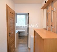 NOVÁ CENA-PREDAJ ZREKONŠTRUOVANÉHO 2-IZBOVÉHO BYTU (50 m2) S LODŽIOU H - Interiér 2-izbového bytu s nábytkom z dreveného dekoru a vešiakom pri vstupe.