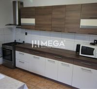 Na predaj rodinný dom v obci Belá nad Cirochou - Kuchyňa v rodinnom dome s dreveným dekorom, varná doska, mikrovlnka, ventilátor.