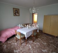 REZERVOVANÝ - Pôvodný rodinný dom v obci Dlhé nad Cirochou - Izba v rodinnom dome s rozkladacím stolom, skriňou a kobercom s dekorom.